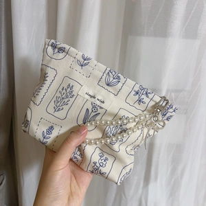 Detail of floral cotton handbag with pearl handle, bow charm, and 'simple wish' label