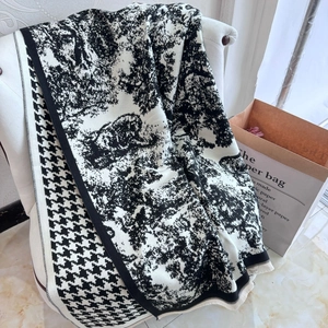 Detailed texture of black and white houndstooth knit shawl with ink landscape pattern