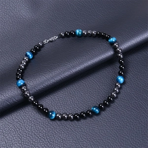 Détail d'un collier en oeil de tigre et onyx noir avec fermoir mousqueton sur cuir