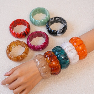 Detailed view of chunky acrylic geometric bracelets with marble textures in various colors