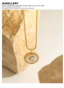 Close-up of golden necklace with shell moon pendant on natural stone background