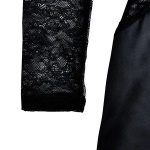 Detail of elegant black lace sleeves and textured fabric on a long dress