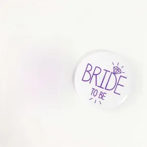 Macro view of purple and white tinplate badges with Team Bride and Bride to Be text