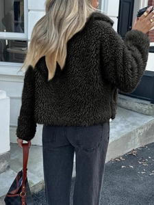 Detail view of deep olive green teddy faux fur jacket with fluffy texture and stylish fit