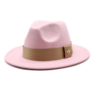 Detail of pink wool fedora hat featuring a khaki ribbon and a small golden bee metal ornament