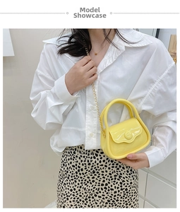 Mini macaron yellow jelly bag featuring a top handle and gold chain shoulder strap