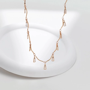 Detailed view of rose gold wavy necklace with rectangular cubic zirconia charms