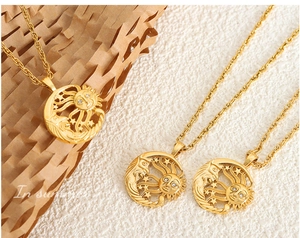 Detail of gold sun and moon pendants with clear rhinestones on delicate rope chains