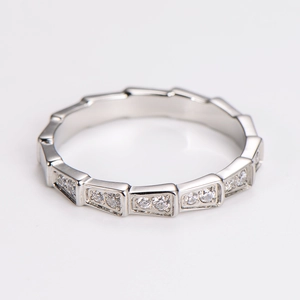 Macro detail of silver snake bone ring with paved crystals in trapezoidal geometric scales