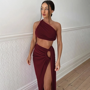 Detail of burgundy backless crop top and high slit skirt set in premium elastic fabric