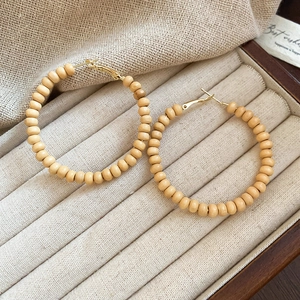 Détail de créoles en bois avec tiges en argent dans une boîte de rangement pour bijoux