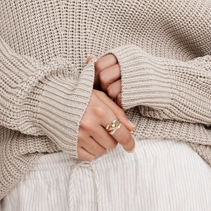 Close-up of minimalist triple-layered interlaced ring in gold, silver and rose gold