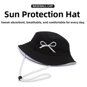 Detail of black cotton bucket hat featuring white bow embroidery and adjustable chin strap