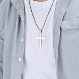 Detail of silver stainless steel cross pendant featuring textured American flag patterns