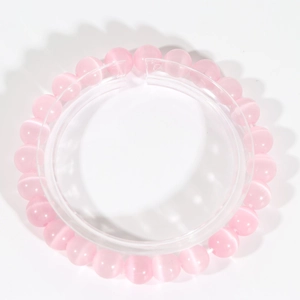 Detail of pink cat-eye stone bead bracelet with 8-10mm round beads on elastic cord