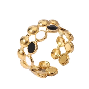 Detail of 18k gold plated ring with linked loops and black and white enamel dots