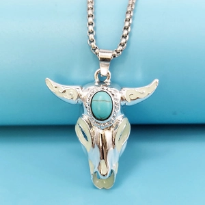 Macro detail of silver bull skull pendant with turquoise stone and luminous finish