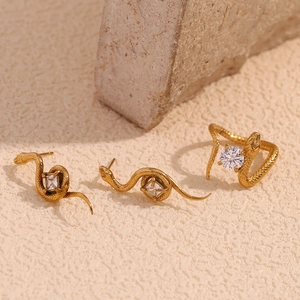 Détail macro de boucles d'oreilles serpent et bague en plaqué or 18 carats et zircon