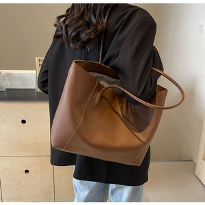 Brown leather tote bag shown on model back for daily commute and styling