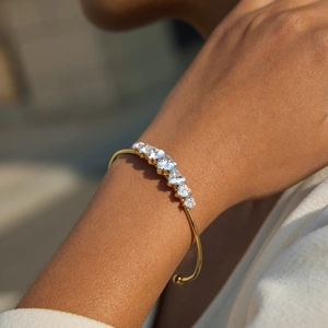Elegant 18K gold plated open bangle with 7 heart-shaped zircons worn on wrist