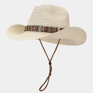Detail of light beige woven straw hat with ethnic leather band and shell ornaments