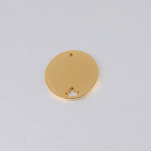 Macro detail of 20mm gold stainless steel round charm with hollow crown cutout design