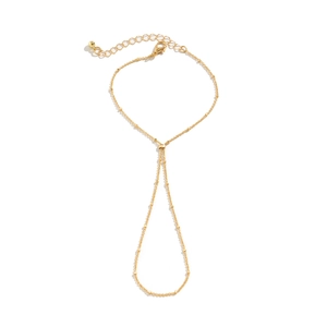 Detailed view of a gold pearl chain bracelet with rhinestone ring and lobster clasp