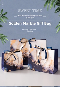 Detailed view of luxury royal blue marble gift bags with gold veins and satin bow ties