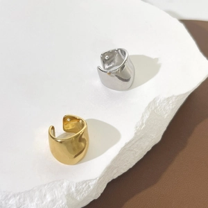Minimalist horseshoe non-pierced ear cuff in gold and silver finish on textured stone