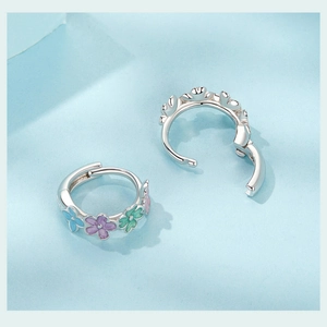 Detail view of colorful floral S925 sterling silver hoop earrings with enamel flower petals
