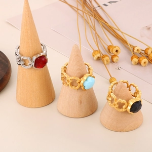 Detailed view of hollow bear patterned rings with colorful gemstones on wooden stands
