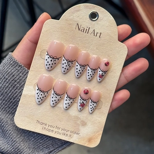 Almond press-on nails with french dots, black bows, and 3D ladybug accents in a 10pc set