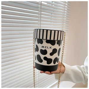 Detail of creative cow print bucket bag featuring gold chain strap and MILK text print