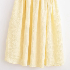 Yellow textured pleated slip dress featuring bright lemon fabric with tree bark pattern