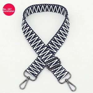 Detail of adjustable blue and white geometric wave shoulder strap with gunmetal hardware