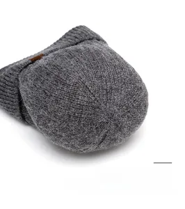 Detail of grey knitted beanie top featuring reinforced spiral stitching and durable seams