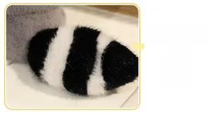 Close-up of the plush raccoon toy showing its fluffy striped tail and soft gray fur