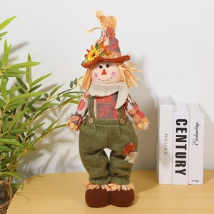 Detail of harvest scarecrow doll featuring telescopic legs and sunflower hat on a desk