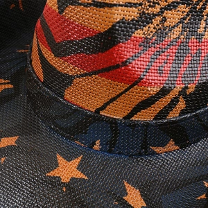 Detail of woven straw cowboy hat with orange star pattern and colorful stripes