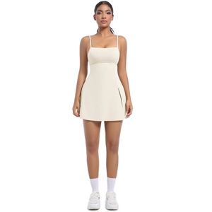 Detail of cream tennis dress featuring thin straps, square neckline and side slit hem
