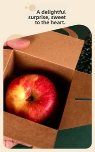 Detail shot of a fresh red apple inside a sturdy brown kraft paper Christmas gift box