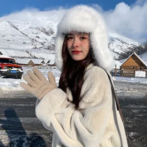 Winter outdoor outfit detail with fluffy white faux fur trapper hat and knit gloves