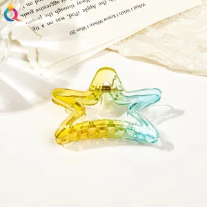 Close-up of star-shaped hair claw with yellow to blue gradient on paper background