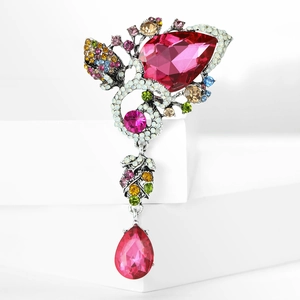 Macro shot of silver butterfly brooch with pink gems and colorful rhinestone pendant