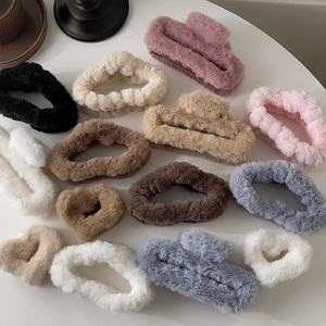 Flat lay of colorful plush hair claws and velvet scrunchies for autumn and winter styles
