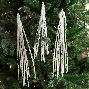 Elegant white pearl garland pendant hanging on a green Christmas tree with warm lights