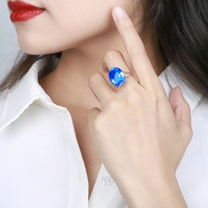 Elegant rose gold bird's nest ring with oval blue gemstone and side accent stones