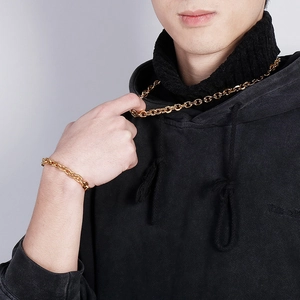 Close-up of gold stainless steel hip hop chain necklace and bracelet set on a male model