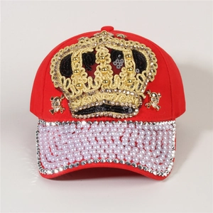 Detailed view of red denim baseball cap with gold crown sequins and pearl rhinestone brim
