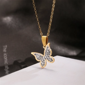 Macro shot of gold butterfly pendant with white fill and sparkling crystal rhinestones